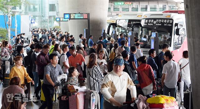 해외여행을 마친 시민들이 8일 오후 인천공항 여객터미널 앞 광역버스 정류장에서 줄을 서서 승차를 기다리고 있다.영종도=고영권기자youngkoh@hankookilbo.com