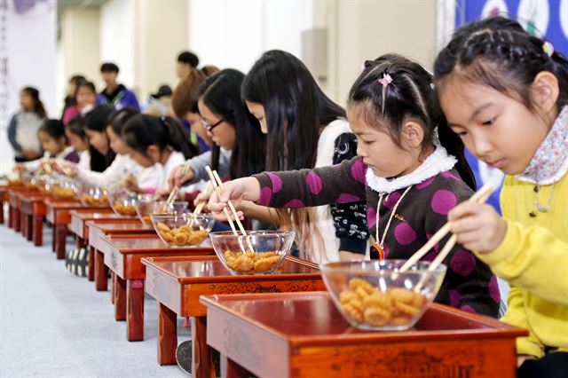 지난해 젓가락경연대회에 참가한 어린이들이 젓가락으로 작은 과자를 집어 옮기는 솜씨를 겨루고 있다. 청주시 제공