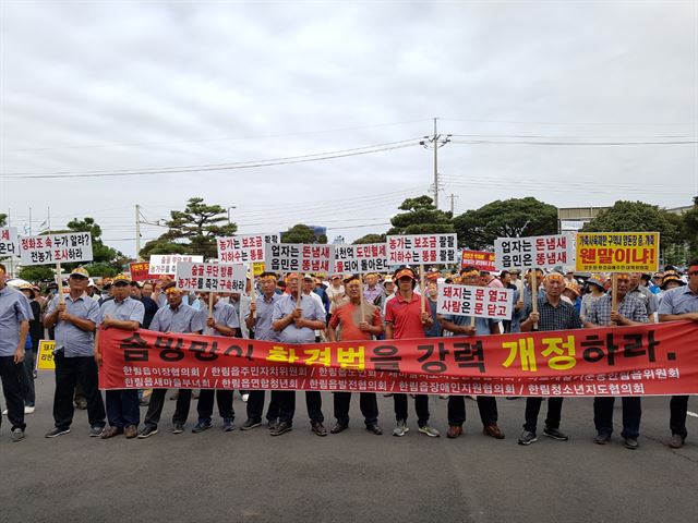 제주시 한림읍 주민들이 8월 29일 한림읍사무소 앞에서 시위를 열고 돼지 분뇨를 무단배출하는 등 환경오염을 유발하는 양돈 농가에 대한 강력한 처벌과 행정 대책을 촉구하고 있다. 한국일보 자료사진.