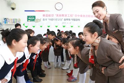 아시아나항공이 17일 중국 네이멍구자치구 후룬베이얼시 하이라얼구에 위치한 ‘원화지에 소학’과 아름다운 교실 자매결연을 맺은 뒤 열린 아시아나항공 현직 승무원의 직업 강의에서 원화지에 소학 학생들이 승무원 체험 실습을 하고 있다. 아시아나항공 제공