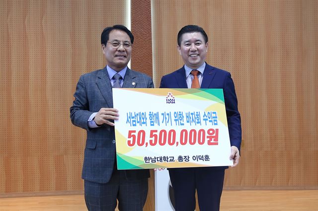 한남대 이덕훈(왼쪽) 총장이 18일 대전기독학원 황순환 이사에게 바자회 수익금을 전달하고 있다. 한남대 제공