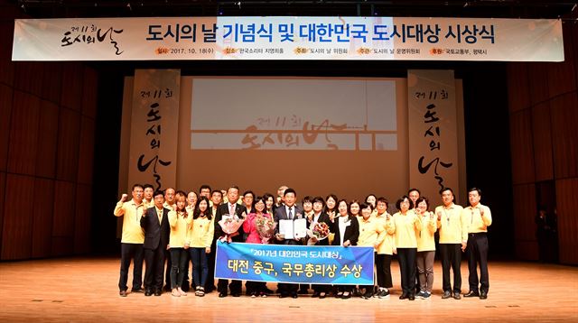 18일 국토교통부 주최로 평택호 관광단지에서 열린 ‘2017년 대한민국 도시대상’ 시상식에서 국무총리상을 받은 대전 중구 박용갑 구청장과 직원들이 수상의 기쁨을 나누고 있다. 대전 중구 제공