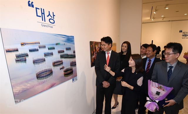 ]19일 오전 서울 서소문 대한항공 빌딩 일우스페이스에서 열린 제24회 대한항공 여행사진 공모전 시상식 및 전시회에 신수진(왼쪽 두번째) 심사위원장이 대상을 수상한 나기환作 '바다와 어부'에 대해 설명하고 있다. 앞줄 왼쪽부터 조원태 대한항공 사장, 신 위원장, 나기환씨 지인. 뒷줄 왼쪽부터 조현민 대한항공 전무, 신무철 전무, 이준희 한국일보 사장. 홍인기 기자