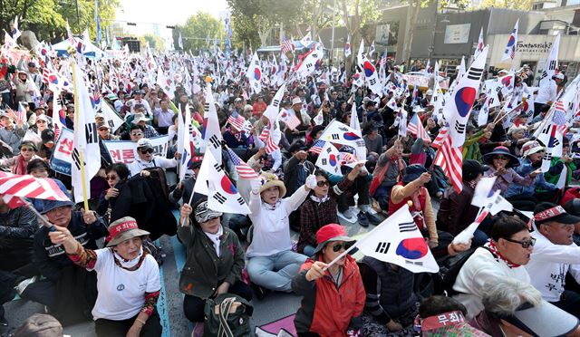 21일 오후 서울 종로구 마로니에공원 주변에서 열린 ‘박근혜 전 대통령 정치투쟁 선언 지지 제20차 태극기 집회’에서 참석자들이 태극기를 들고 구호를 외치고 있다. 뉴스1