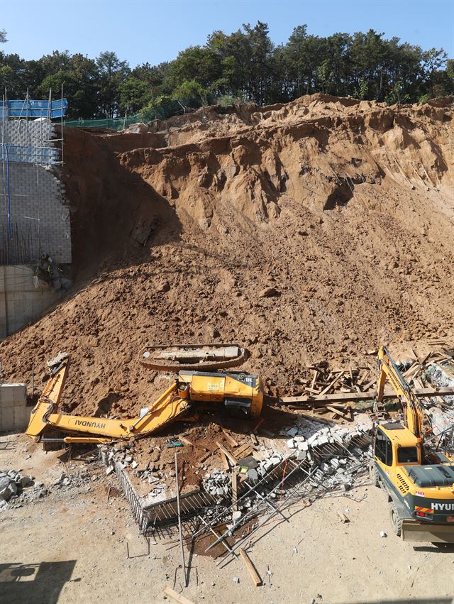 23일 오전 10시 30분께 경기도 용인시 처인구 한 물류센터 건설현장에서 옹벽이 무너져 지하 1층에서 공사 중이던 작업자 2명과 굴삭기 등 장비가 매몰됐다. 현장에 출동한 소방당국은 곧바로 구조작업을 실시, 1명을 구조, 1명은 숨진채 발견되었다. 사고 당시 사진은 소방대원들이 매몰자를 수색하고 있는 모습. 용인=연합뉴스