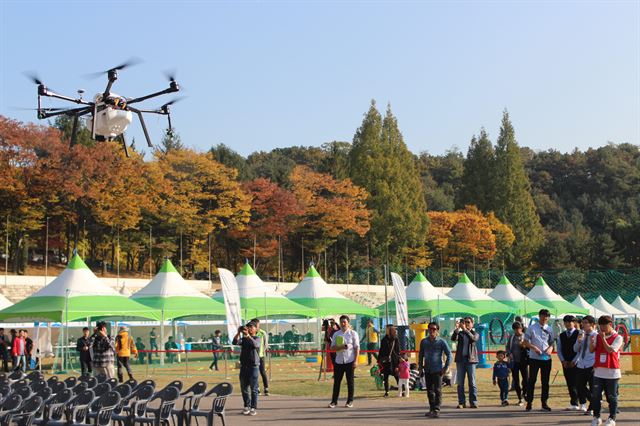 27일 경기 용인시 옛 경찰대에서 개막한 ‘2017 용인드론페스티벌’에서 농약 살포용 드론이 공중에서 시연을 펼쳐 보이고 있다. 이종구 기자