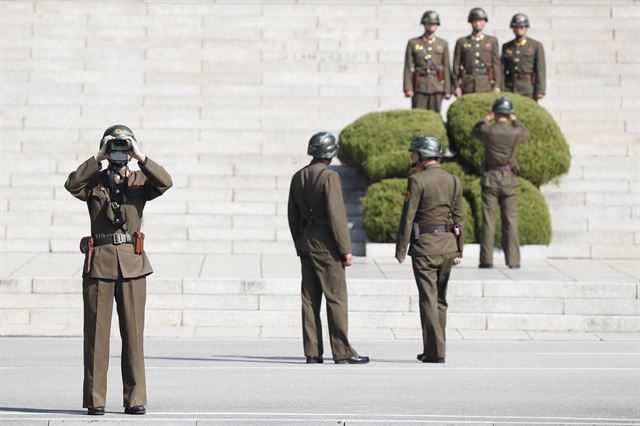 한국을 방문한 제임스 매티스 미 국방장관과 송영무 국방장관이 27일 경기도 파주 판문점 공동경비구역(JSA)를 방문 중인 가운데 북측 판문각 앞에서 한 북한 군인이 쌍안경을 이용해 한,미 국방장관을 바라보고 있다. EPA 연합뉴스