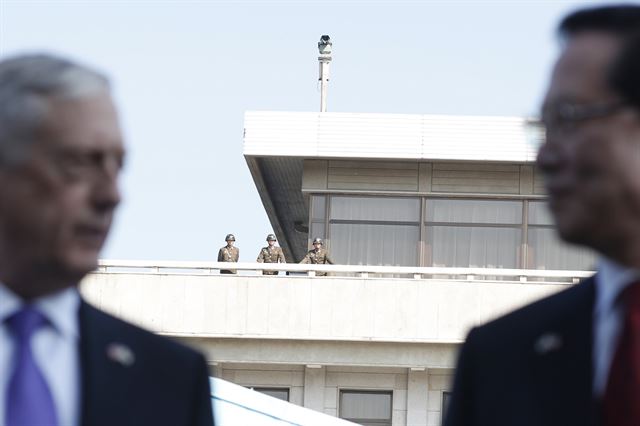 경기도 파주 판문점의 북측 판문각에서 27일 북한 군인들이 판문점 공동경비구역을 방문한 제임스 매티스 미 국방장관과 송영무 국방장관이 대북 메시지를 발표하는 모습을 바라보고 있다. EPA 연합뉴스