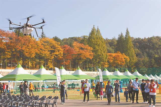 27일 경기 용인시 옛 경찰대에서 열린 ‘2017 용인 드론페스티벌’에서 농약 살포용 드론의 공중 작업 모습이 시연되고 있다. 드론페스티벌에는 드론 경주대결과 에어쇼, 군무 등 아이들 호기심을 자극할 만한 프로그램과 드론 조종교육ㆍ체험, 드론 시뮬레이터, 드론만들기 등 다채로운 행사들이 열린다. 무인비행장치인 드론의 관련 산업에 필요한 미래 인재를 육성하기 위해 용인디지털산업진흥원이 주관하고 한국일보 등이 후원하는 이번 행사는 28일까지 진행된다. 이종구 기자