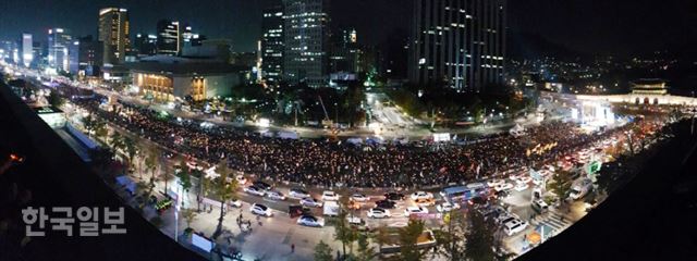 28일 저녁 서울 종로구 광화문 광장에서 박근혜정권퇴진 비상국민행동 기록기념위원회 주최로 열린 촛불 1주년 기념대회 '촛불은 계속된다'에 참석한 시민들이 촛불을 높이 들고 있다. 홍인기 기자