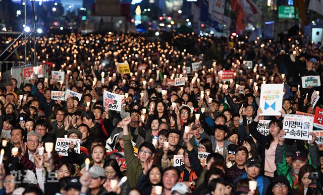 28일 저녁 서울 종로구 광화문 광장에서 박근혜정권퇴진 비상국민행동 기록기념위원회 주최로 열린 촛불 1주년 기념대회 '촛불은 계속된다'에 참석한 시민들이 촛불을 높이 들고 있다. 홍인기 기자