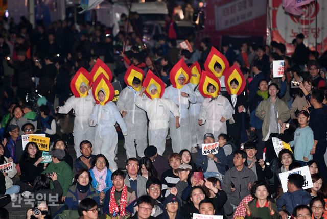 28일 저녁 서울 종로구 광화문 광장에서 박근혜정권퇴진 비상국민행동 기록기념위원회 주최로 열린 촛불 1주년 기념대회 ‘촛불은 계속된다’에 촛불 모형으로 분장한 시민들이 참석해 춤을 추고 있다. 홍인기 기자