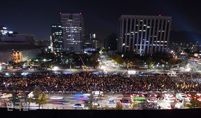 28일 저녁 서울 종로구 광화문 광장에서 박근혜정권퇴진 비상국민행동 기록기념위원회 주최로 열린 촛불 1주년 기념대회에 참석한 시민들이 촛불을 높이 들고 있다. 홍인기 기자