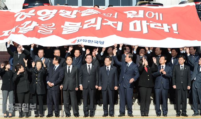 자유한국당 정우택 원내대표와 의원들이 30일 국회 본관 앞 계단에서 정부 여당을 겨냥해 '공영 방송 장악 및 북핵 압박 UN 결의안 기권 규탄대회'를 하며 대형 현수막을 펼치고 있다. 의원들은 이날 원내대표의 사전 공지로 '상복'을 입었다. 오대근 기자 inliner@hankookilbo.com