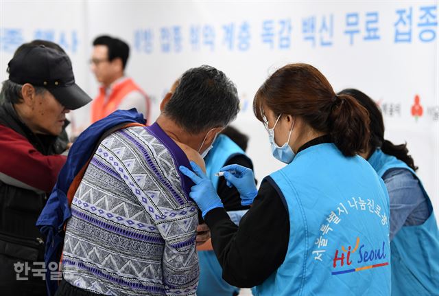 31일 오전 서울 용산구 무료급식소 '따스한 채움터'에서 자원봉사자들이 노숙인 및 쪽방촌 주민들에게 독감백신을 접종하고 있다. 홍인기 기자