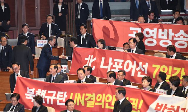 문재인 대통령이 2018년도 예산안 관련 시정연설에서 연설을 마치고 나가며 자유한국당 의원들이 현수막을 들고 항의시위 하는 위치까지 다가가 손을 내밀어 악수를 하고 있다. 오대근기자