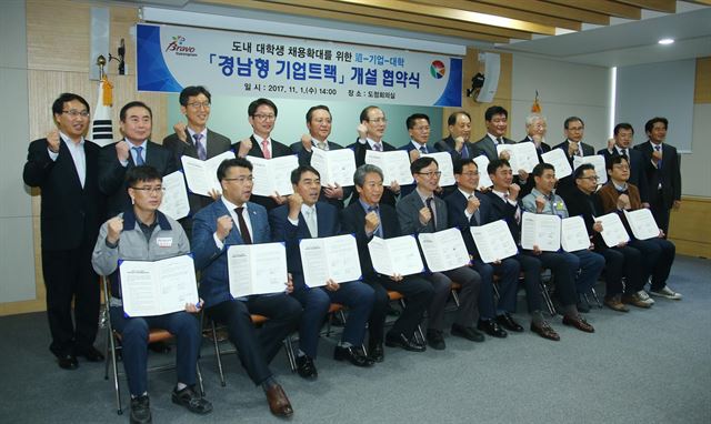 1일 경남도청에서 열린 ‘경남형기업트랙’ 협약에 참여한 한경호(뒷줄 왼쪽에서 일곱번째)경남지사 권한대행과 무학 등 도내 10개 기업, 경남대 등 도내 9개 대학 관계자들이 협약 체결 후 파이팅을 외치고 있다. 경남도 제공