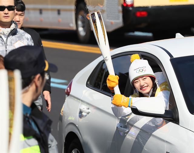 평창 동계올림픽 국내 성화봉송 이틀째인 2일 오후 제주지역 성화봉송 첫 주자로 선정된 걸그룹 아이오아이 김소혜가 제주국제공항 앞 공항로에서 전기자동차를 타고 성화를 봉송하고 있다. 연합뉴스.