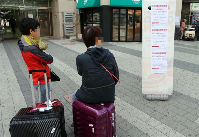 경상남도 시외버스 노조 소속 기사들이 파업이 돌입한 3일 오전 부산 사상구 서부시외버스터미널에서 승객들이 경남 노선 중단되는 알리는 안내문을 읽고 있다.부산=연합뉴스