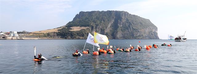 2018 평창 동계올림픽 국내 성화봉송 사흘째인 3일 제주 서귀포시 성산읍 광치기해변에서 해녀들이 수중에서 이색 성화 봉송을 하고 있다. 서귀포=연합뉴스