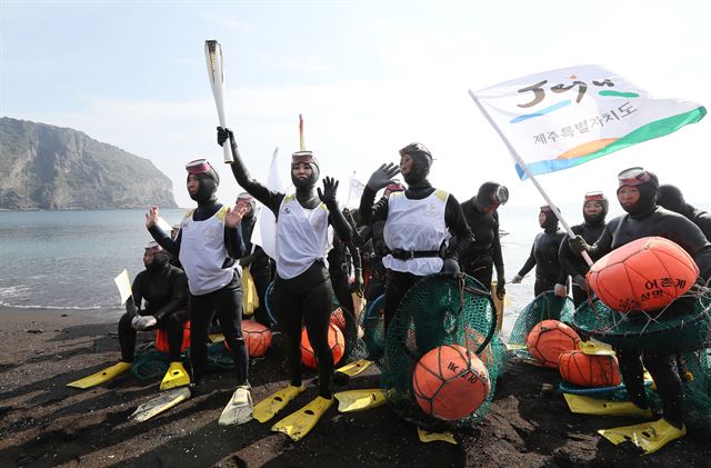 02018 평창 동계올림픽 국내 성황봉송 사흘째인 3일 제주 서귀포시 성산읍 광치기해변에서 해녀들이 수중에서 성화 봉송을 한 뒤 환호하고 있다. 서귀포=연합뉴스