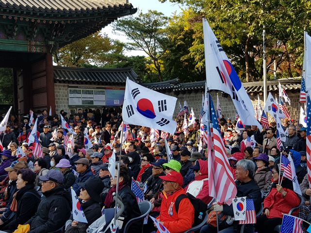 4일 서울 중구 대한문 앞에서 ‘태극기시민혁명 국민운동본부’ 주최로 열린 태극기 집회에서 참가자들이 트럼프 미국 대통령 방한을 환영하며 미국 국기를 흔들고 있다. 신은별 기자