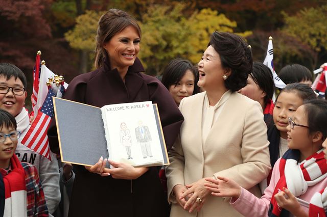 김정숙 여사와 멜라니아 여사가 7일 오후 청와대 녹지원에서 공식환영식에 참가했던 한.미 어린이 환영단 중 한 어린이가 준비한 그림집(트럼프 대통령 내외를 그린)을 살펴보고 있다. 고영권 기자