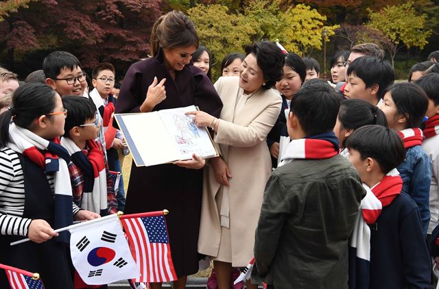 김정숙여사와 멜라니아 여사가 7일 오후 청와대 녹지원에서 공식환영식에 참가했던 한.미 어린이 환영단 중 한 어린이가 준비한 그림집(문재인 대통령 내외.트럼프 대통령 내외를 그린)을 살펴보고 있다. 고영권기자