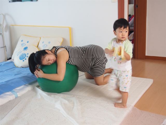 엄마가 진통하는 중에 첫째 아들이 그 곁에서 간식을 먹고 있다. 신정민씨 제공