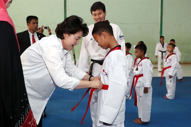 문재인 대통령 부인 김정숙 여사가 9일 오전(현지시간) 인도네시아 보고르시 빠룽에 소재한 알 아쉬리야 누룰 이만 이슬람 기숙학교 내 태권도장에서 한 학생에게 태권도 띠를 메주고 있다. 보르고=고영권기자