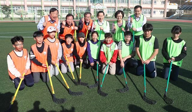 김상곤 사회부총리 겸 교육부 장관과 이희범 2018 평창동계올림픽 조직위원장, 민병희 강원도교육감을 비롯한 평창지역 교육관계자들이 9일 강원도 평창군 횡계초등학교를 찾아 학생들과 함께 아이스하키를 변형한 플로어볼 게임을 즐긴 후 기념촬영하고 있다. 뉴스1