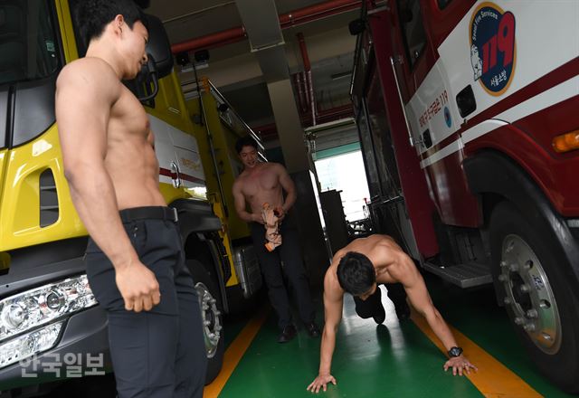 10일 서울 서초소방서에서 몸짱 소방관 희망나눔달력 홍보를 위해 소방관 모델들이 포즈를 취하기 전 운동을 하고 있다. 서재훈기자