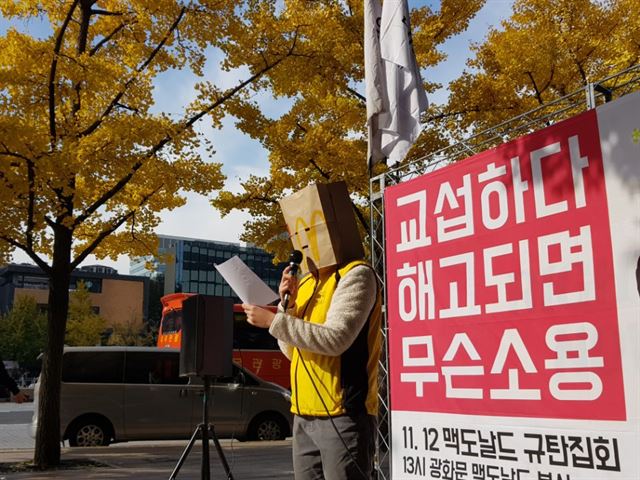 12일 서울 종로구 맥도날드 본사 앞에서 열린 '교섭하다 해고되면 무슨 소용? 맥도날드 규탄집회'에서 한 맥도날드 알바노동자가 신변보호를 위해 맥도날드 종이 봉투를 쓰고 발언하고 있다. 홍인택 기자