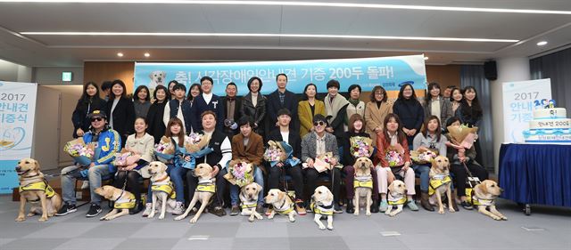 13일 서울 서초동 삼성화재 본사에서 안내견을 받은 시각장애인과 자원봉사자 등이 기념촬영을 하고 있다. 삼성화재안내견학교 제공