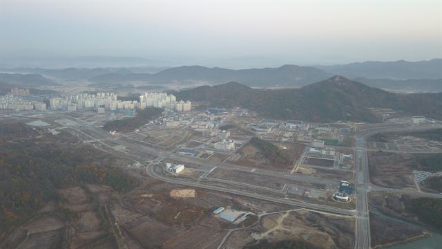 경북도청 신도시의 아침이 밝아오고 있다. 검무산 아래로 경북도교육청(오른쪽부터)과 지난달 문을 연 경북도대외통상교류관, 경북도청이 보이고, 도청과 아파트촌 사이로 경북경찰청이 한창 공사 중이다. 도청신도시에는 이달 현재 이전대상 유관기관ㆍ단체 107곳 중 이전 완료 30곳, 공사진행 7곳, 설계 13곳 등 69곳이 이전을 끝냈거나 추진 중이다. 주민등록 인구는 2,652세대 6,741명이고 거주인구는 4,185세대 1만여명으로 집계되고 있다. 상가는 97개동 716곳이 건축을 끝내 248곳이 입점했다. 아파트는 7개 단지가 완공됐고, 3개 단지가 건설 중이다. 경북도는 내년 초 본격적으로 도청신도시 2단계 개발사업 조성공사를 시작한다. 전준호기자 jhjun@hankookilbo.com