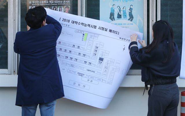 포항 지진 여파로 대학수학능력시험이 1주일 뒤로 연기된 16일 오전 부산의 한 시험장에서 관계자들이 수험생을 위해 부착해둔 고사장 배치도를 철거하고 있다. 연합뉴스