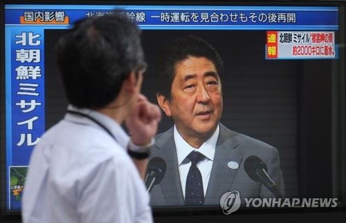 북한의 미사일 발사 당시 TV 긴급속보 화면을 한 시민이 지켜보고 있다. [도쿄 AFP=연합뉴스 자료사진]