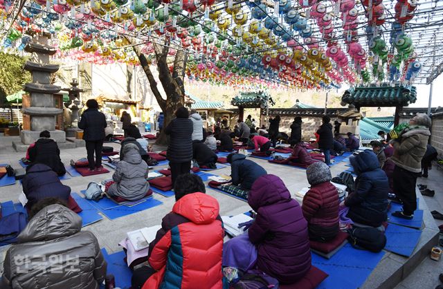 포항 지진 발생으로 수능이 일주일 연기된 가운데 영하의 날씨를 기록한 19일 오전 서울 우이동 도선사에서 학부모들이 두툼한 겨울 옷을 입고 기도를 하고 있다. 홍인기 기자