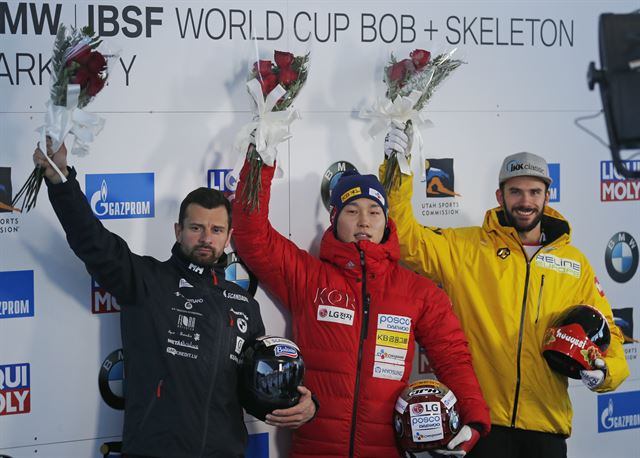 윤성빈(가운데)이 19일(한국시간) 미국 유타주 파크시티에서 열린 2017~18 IBSF 월드컵 2차 대회 남자 스켈레톤에서 ‘황제’ 마르틴스 두쿠르스(왼쪽)를 0.63초 차이로 제치고 우승을 차지한 뒤 시상대에서 포즈를 취하고 있다. 파크시티=AP 연합뉴스