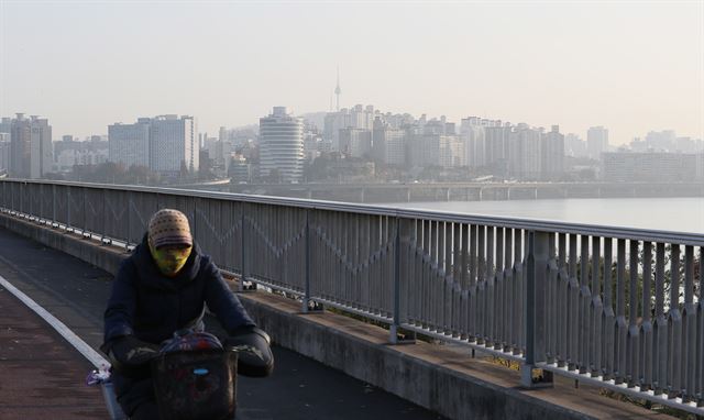 미세먼지로 하루종일 서울의 하늘이 뿌옇던 14일 서울 여의도 마포대교를 한 시민이 자전거로 지나고 있다. 연합뉴스