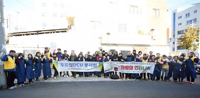 연탄 나눔 봉사에 나선 대구사이버대 DCU두드림봉사단 및 교직원 들과 대한적십자 대구지사 직원들이 20일 대구시 동구 신천동 일대에서 연탄 나르기 봉사 활동을 하고 기념촬영을 하고 있다. 대구사이버대 제공