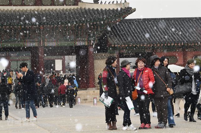 20일 오후 서울 경복궁을 찾은 관광객들이 첫 눈을 맞으며 즐거워하고 있다. 배우한 기자