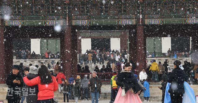 20일 오후 서울 경복궁을 찾은 관광객들이 첫 눈을 맞으며 즐거워하고 있다. 배우한 기자