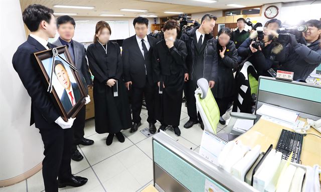 세월호 미수습자 양승진 교사, 남현철 군, 박영인 군의 발인이 엄수된 20일 오전 경기 안산시 단원고등학교에서 양승진 교사의 유가족이 영정을 들고 고인이 근무했던 교무실을 둘러보고 있다. 안산=연합뉴스