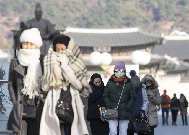 서울 최저기온 영하 6도를 기록한 19일 오전 서울 광화문광장에서 관광객들이 추위에 떨며 길을 걷고 있다. 연합뉴스