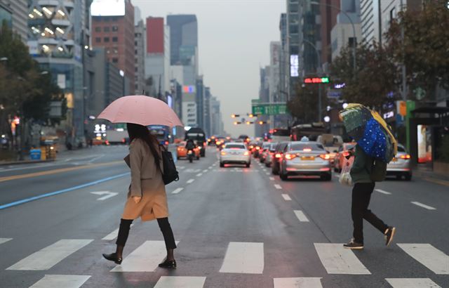 절기상 첫눈이 내린다는 소설(小雪)인 22일 오전 비 내리는 서울 시내거리에서 시민들이 발걸음을 재촉하고 있다. 연합뉴스