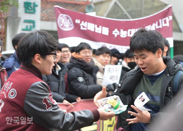 수능 당일 오전 서울 종로구 경복고등학교 앞에서 중앙고등학교 학생회 학생들이 수험생에게 응원 선물을 전달하고 있다. 박미소 인턴 기자