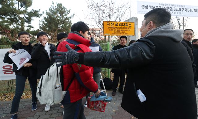 대학수학능력시험일인 23일 경북 포항시 남구 오천읍에 있는 수능 시험장인 포은중학교에서 한 수험생이 후배들의 응원을 받으며 시험장을 향하고 있다. 연합뉴스