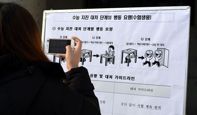 수능을 하루 앞둔 22일 오후 서울 여의도여자고등학교에서 한 수험생이 수능 지진 대처 단계별 행동 요령을 확인하고 있다. 배우한 기자