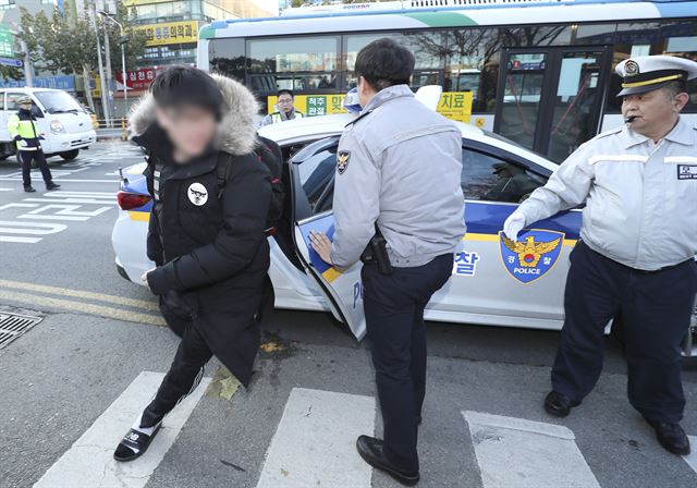 대학수학능력시험일인 23일 오전 수능시험장인 청주시 청주고등학교 앞에서 한 수험생이 경찰 순찰차에서 내려 급히 시험장으로 달려가고 있다. 연합뉴스